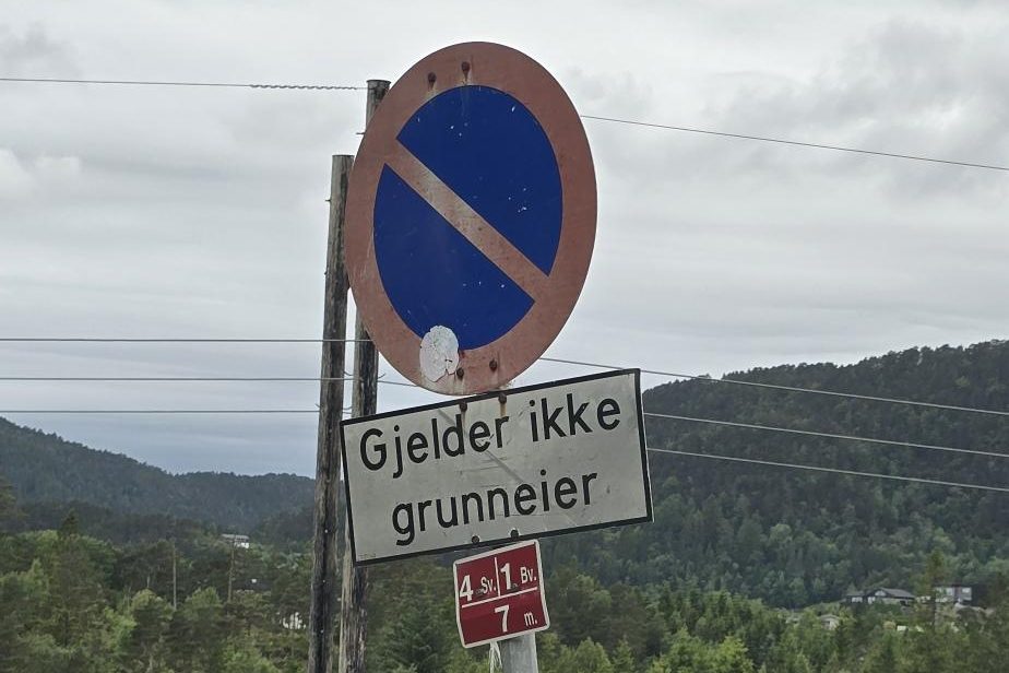 Skilt 372 parkering forbudt med underskilt med fritekst «Gjelder ikke grunneier» på en vei i skogen